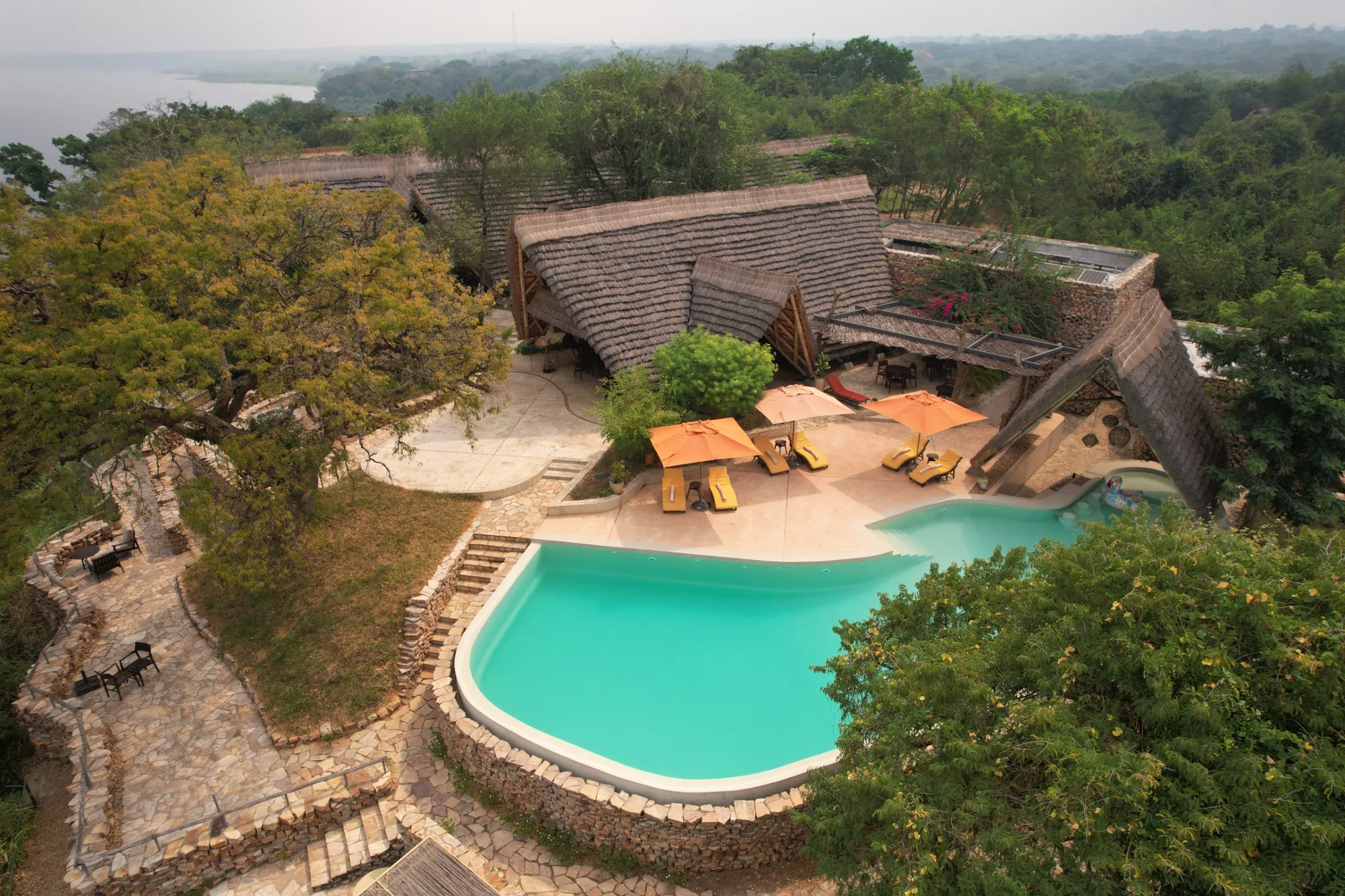 Thatched roofs, the pool and the stone terraces of the lodge