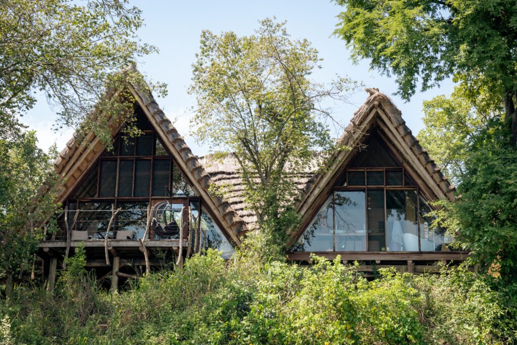 Thatched-roof Deluxe Banda chalets at Nile Safari Lodge, nestled along the Nile River, blending eco-luxury with African safari elegance.